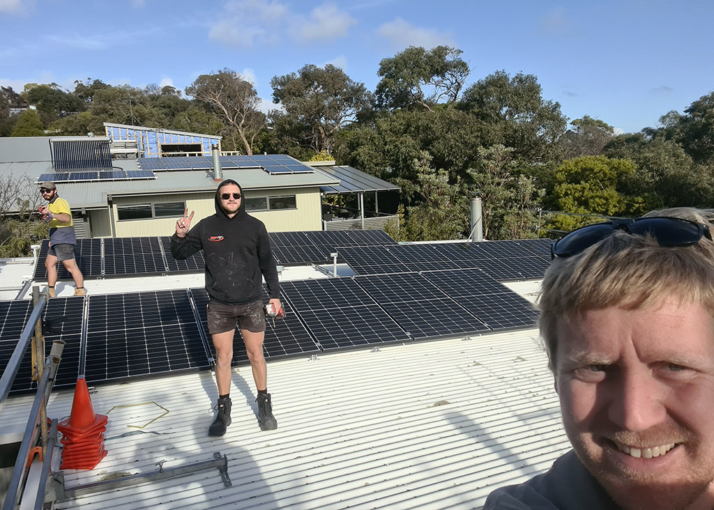 Qualified electricians at work on a roof top.
