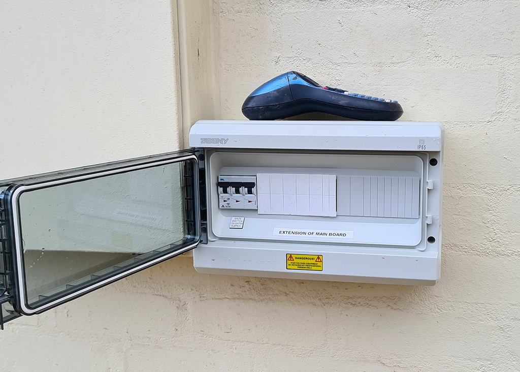 A domestic electrical box installed on a light cream wall.