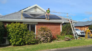 An electrician on a roof in Geelong dismantling a safety guard rail after a domestic solar install.