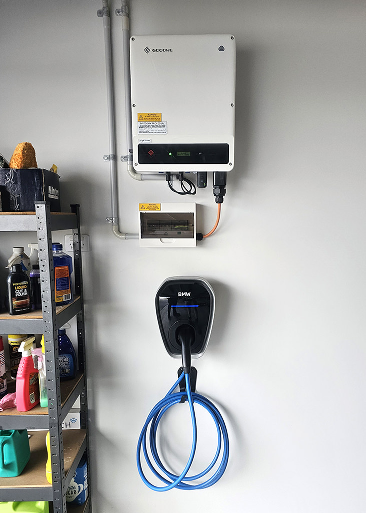 A BMW wall charger for an EV vehicle installed on the wall inside a domestic garage.