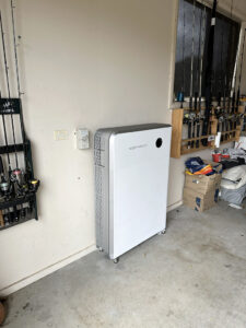 Sigenergy SigenStor battery backup system installed on a garage wall next to storage.